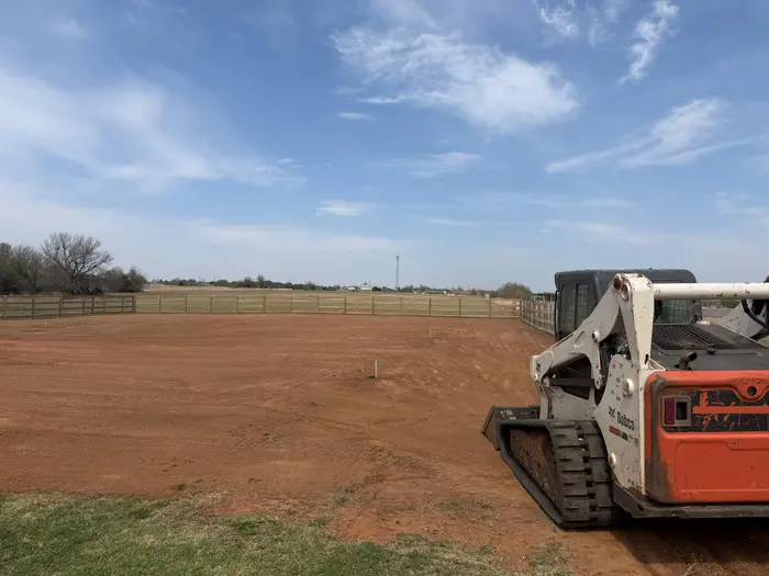 Skid steer parked on a laser flat arena pad