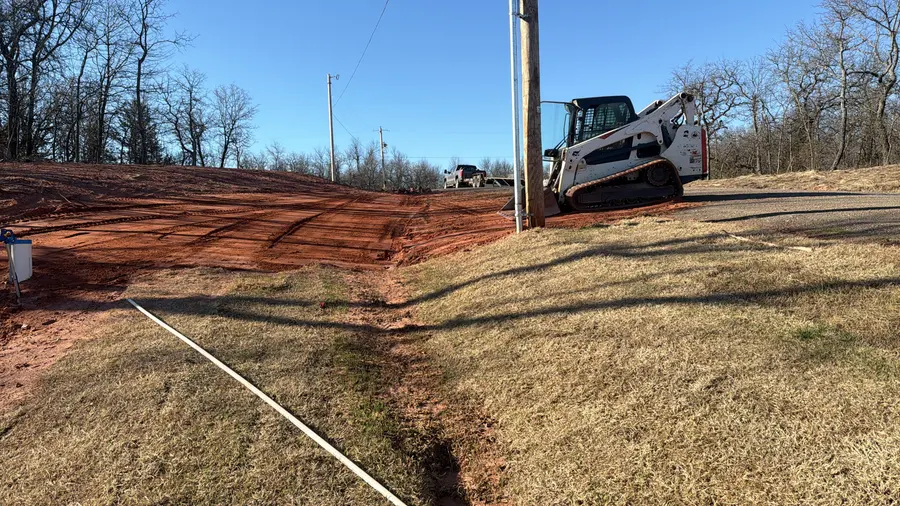 Track loader cutting a driveway approach